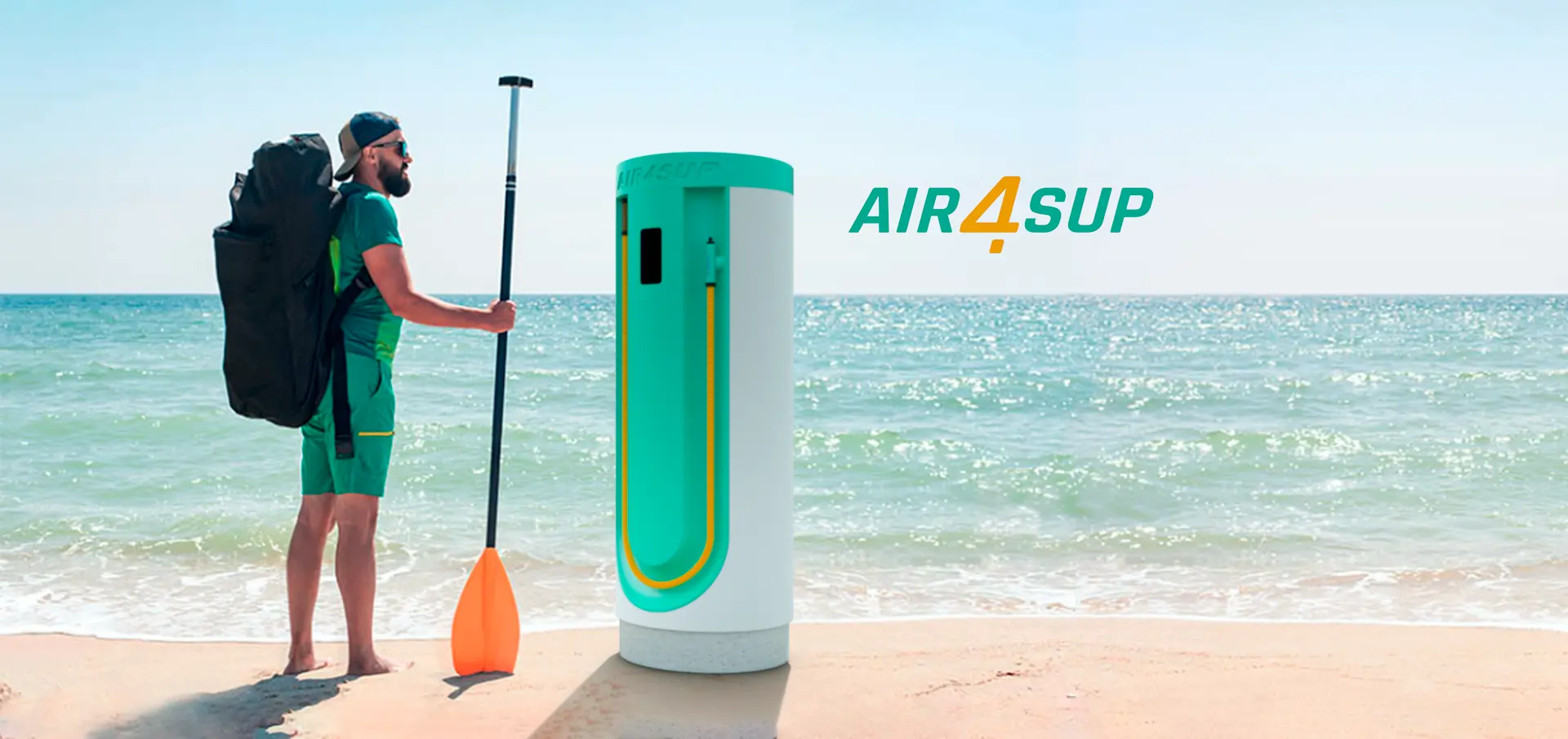 Ein Foto eines Mannes am Strand mit seinem SUP in seinem Rucksack bereit zum Aufpumpen an der Air4SUP Station.